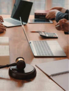 Imagem representativa do ramo do direito empresarial, com uma mesa de escritório, um malhete de juiz, notebooks e livros de advocacia. A imagem foi usada no site oficial da Advogada Bruna Marçal.
